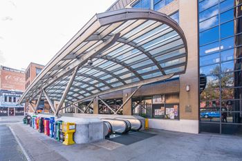 A row of colorful trash cans are lined up outside a building.at Elysium Fourteen, Washington, 20009